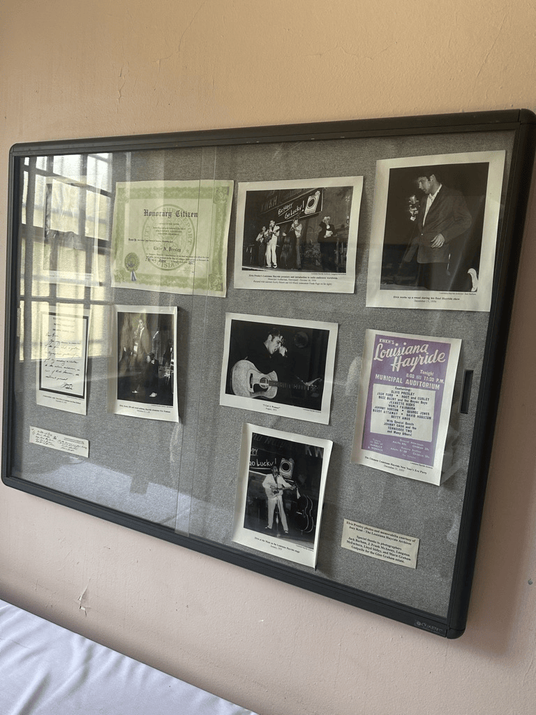 A display case featuring a collection of historical photographs and documents related to musical performances, including a certificate of honorary citizenship and various concert announcements.